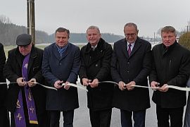 Otwarcie kolejnych gminnych dróg przebudowanych dzięki Rządowemu Funduszowi Rozwoju Dróg. Osoby przecinające wstęgę.